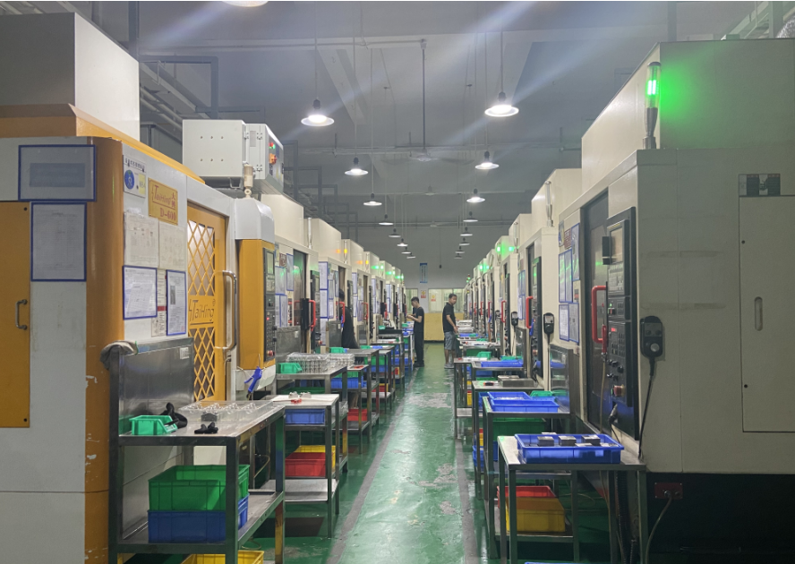 Employees working between CNC machining centers on the production floor
