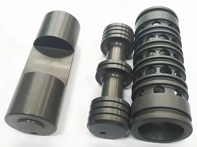 Dark hard-anodized cylindrical parts with grooves, shoulders and machined flats
