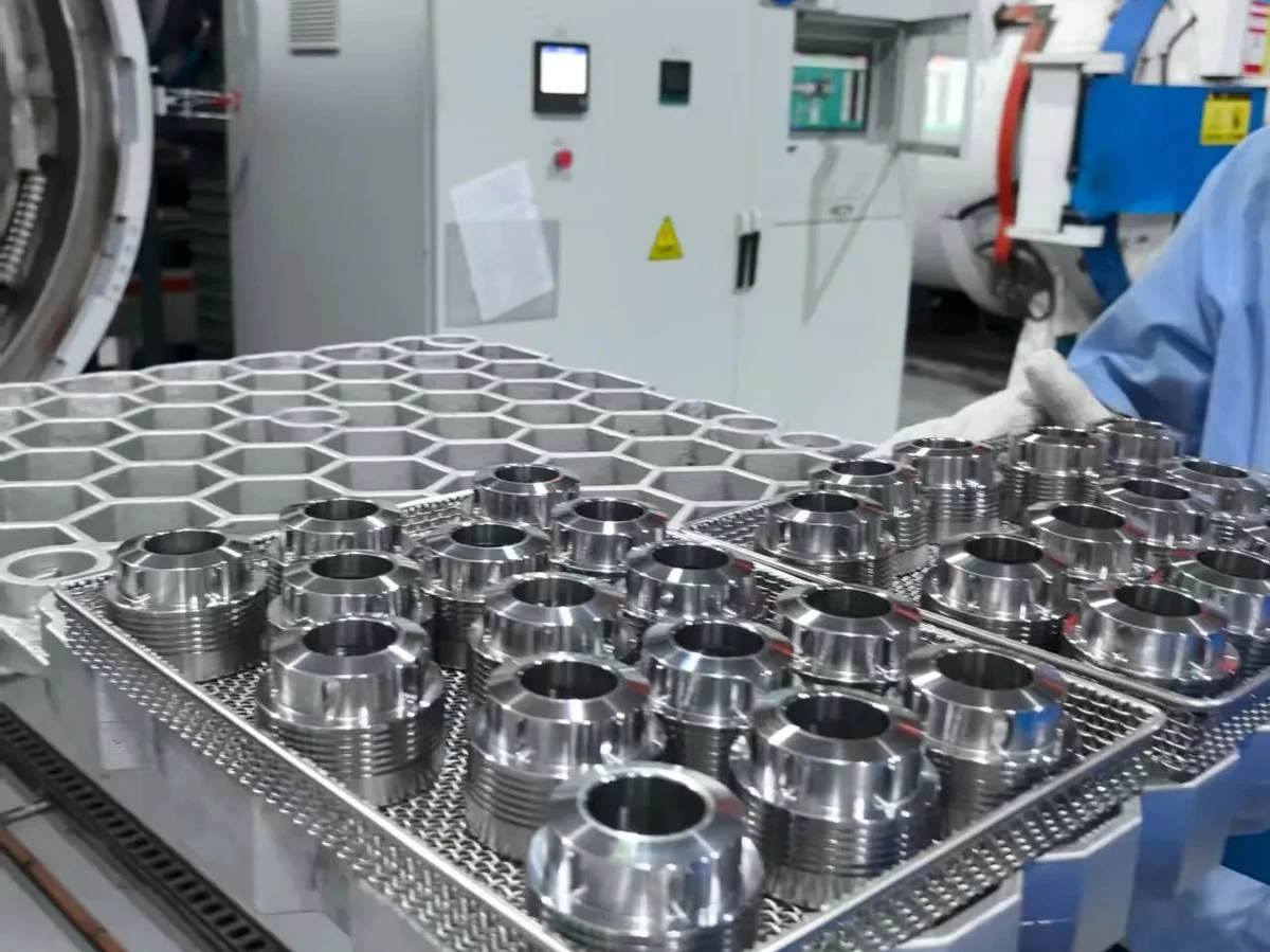 Metal components on processing trays beside heat-treatment equipment