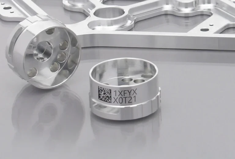 Machined metal ring with a two-dimensional code and alphanumeric laser marks on its outer surface