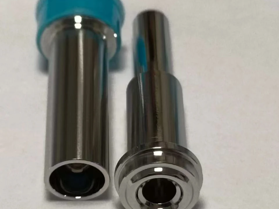 Two polished metal components with reflective cylindrical surfaces and hollow bores
