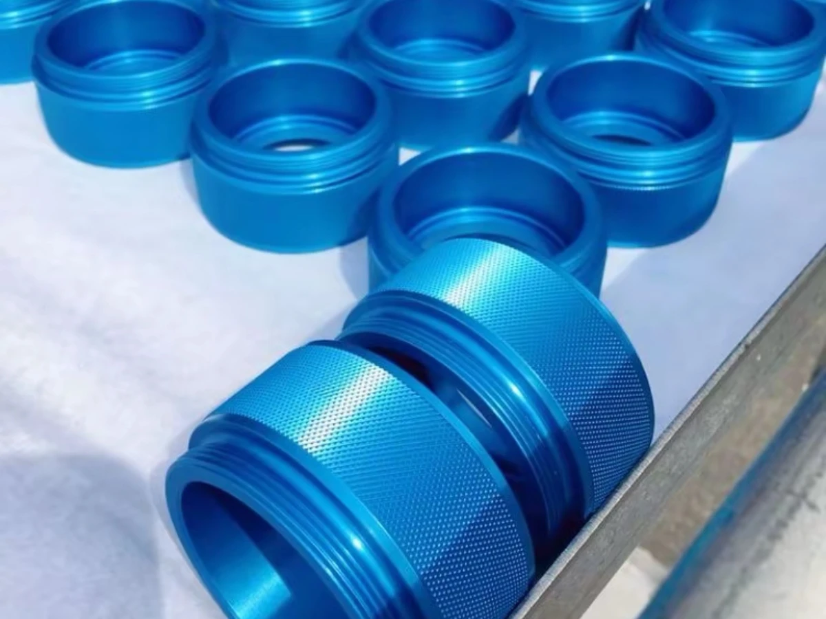 Blue anodized titanium components with threaded bores and knurled outer surfaces