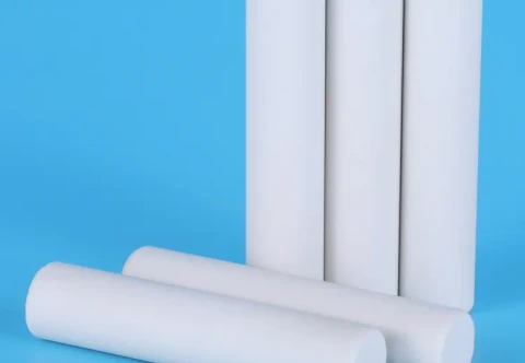 Solid white ceramic cylindrical blanks on a blue surface