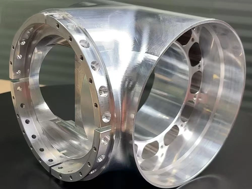Machined metal housing with large intersecting bores, flanges and drilled mounting holes