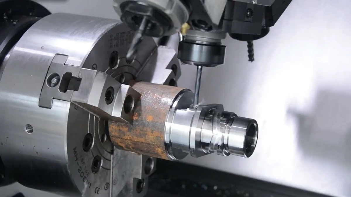 Live milling tool machining a stepped cylindrical component held in a lathe chuck