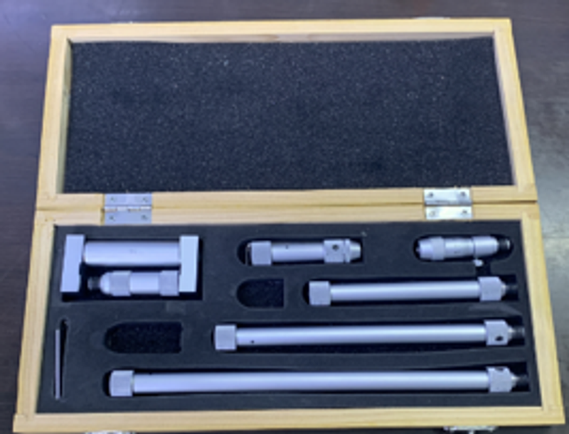 Inside micrometer head and extension rods arranged in a wooden instrument case