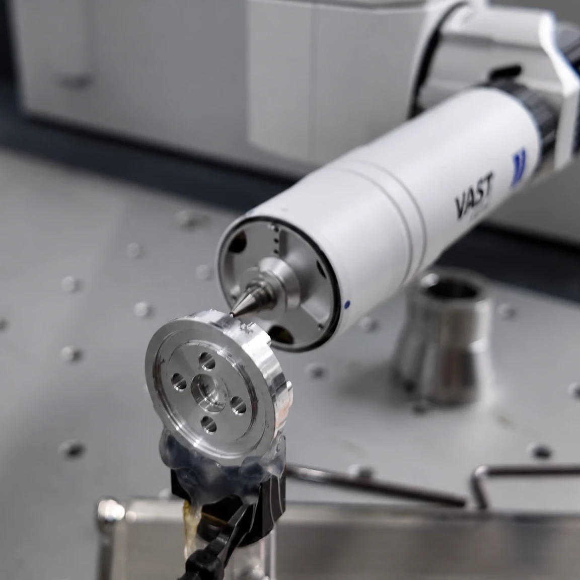 Coordinate measuring probe contacting a machined circular flange held in a fixture on an inspection table