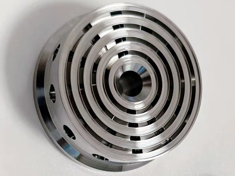 Machined metal ring with concentric grooves, a central bore and radial openings