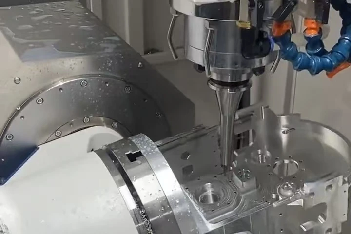 CNC milling spindle cutting a metal workpiece on a rotary fixture